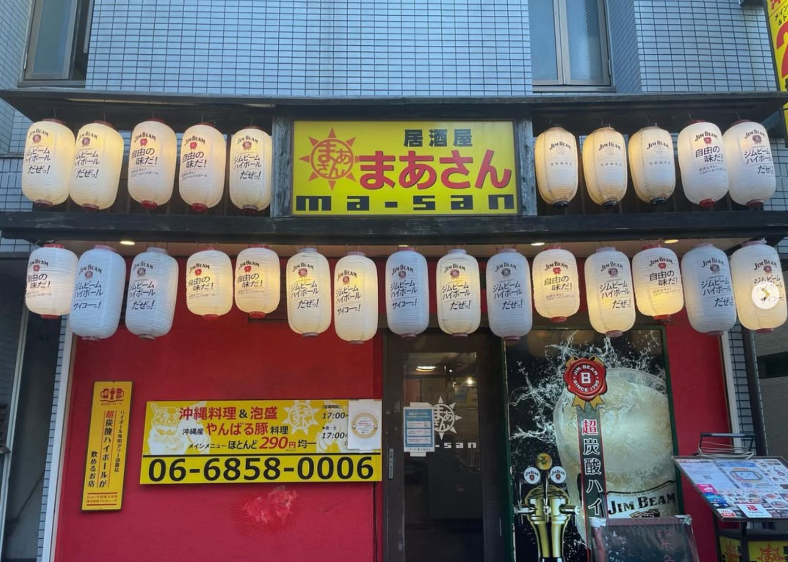 居酒屋まあさん豊中駅前店の外観。赤い壁にジムビームの提灯が並ぶ店構え