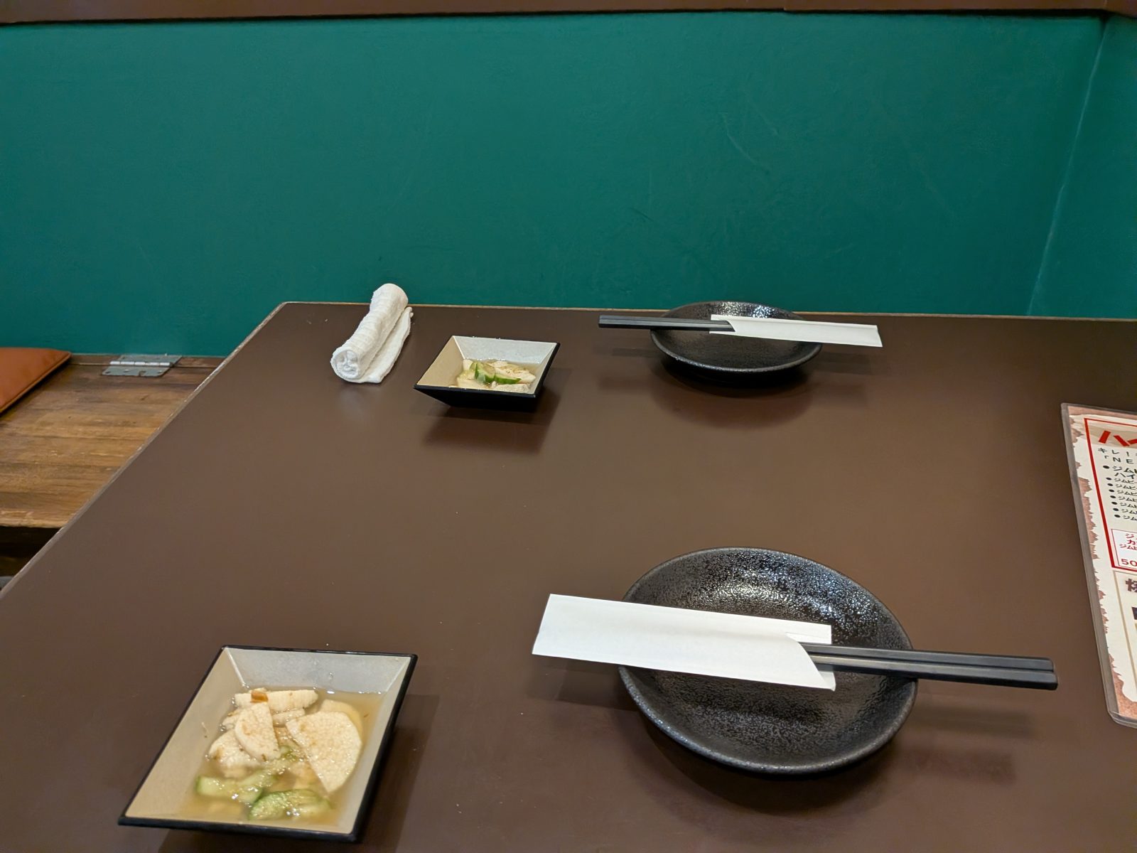 居酒屋まあさん豊中駅前店の店内。深い緑の壁とテーブル席